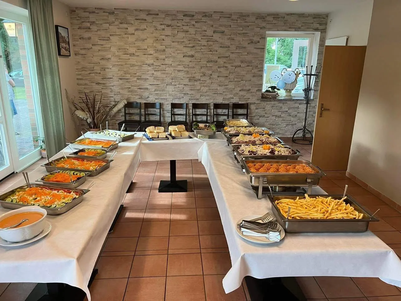 Reich gedecktes Buffet mit Salaten, warmen Speisen und Beilagen in Chafing-Dishes