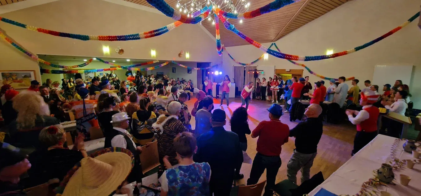 Ausgelassene Party: fröhliche Gäste in Kostümen mit bunten Luftschlangen