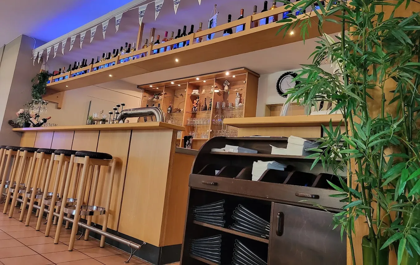 Unsere Weinbar mit einer Wand voller Flaschen, warmem Holz und gedämpftem Licht